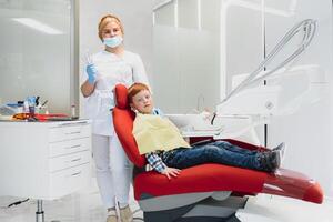 fêmea dentista e criança dentro uma dentista escritório foto