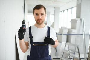 homem drywall trabalhador instalando placa de gesso Folha para muro. foto