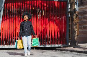 atraente jovem afro-americano mulher compras - compras bolsas, ao ar livre, rua visualizar, adequado para feriado compras temas, entre outras foto