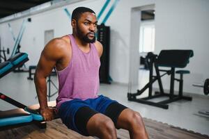 peso Treinamento africano fazendo musculação dentro academia. foto