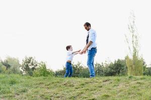 feliz Tempo com pai. família Diversão conceito. barbudo homem e fofa filho crianças sorriso. Primavera Tempo andar com pai. foto