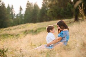 mãe e filho tendo descansar em período de férias dentro montanhas. foto