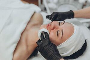 uma menina às uma cosmetologista faz Cosmético procedimentos. pele limpeza foto