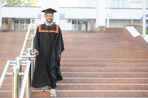 retrato do indiano bonito masculino graduado dentro graduação manto. foto