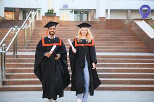 Educação, graduação e pessoas conceito - feliz internacional alunos dentro argamassa Pranchas e solteiro vestidos. foto