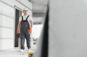 homem construtor. arquiteto é em pé dentro prédio. retrato do pensando construtor. construtor arquiteto dentro inacabado prédio. arquiteto dentro trabalhando uniforme. foto