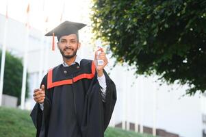 Educação, graduação e pessoas conceito - feliz indiano masculino graduado estudante. foto