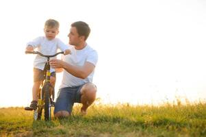 pai ensino dele filho quão para passeio uma bicicleta foto