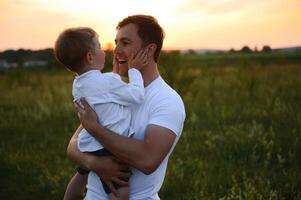 feliz pai jogando com filho em pôr do sol fundo .o conceito do do pai dia foto