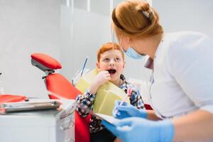 Garoto satisfeito com a serviço dentro a dental escritório. conceito do pediatra dental tratamento foto