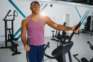 peso Treinamento africano fazendo musculação dentro academia. foto