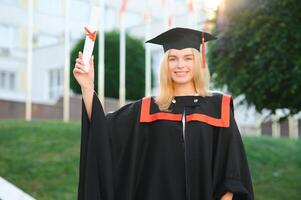 retrato do uma feliz mulher em dela graduação dia às universidade. Educação e pessoas. foto