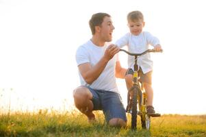 pai ensino dele filho quão para passeio uma bicicleta foto