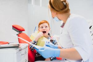 fêmea dentista e criança dentro uma dentista escritório foto