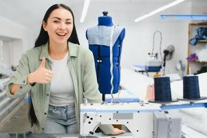 jovem mulher trabalhando Como costureira dentro roupas fábrica. foto