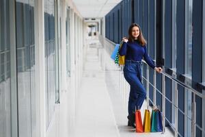 retrato do menina em pé dentro a Shopping depois de fazendo compras foto