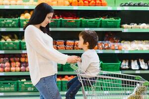 mãe e criança compras às agricultores mercado para frutas e legumes foto