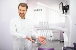 jovem masculino dentista dentro clínica foto
