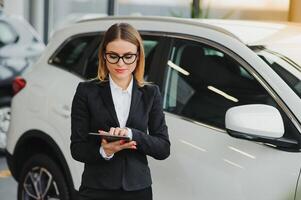 lindo jovem mulher compra uma carro dentro a concessionária salão. foto