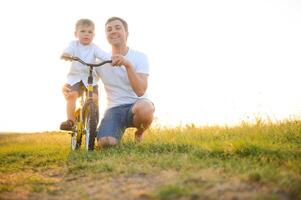 pai Socorro dele filho passeio uma bicicleta foto