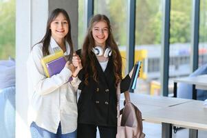 sorridente meninas dentro Alto escola corredor. dois fêmea Faculdade alunos falando depois de palestra. foto