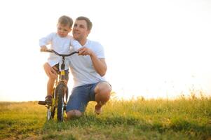 do pai dia. Papai e filho jogando juntos ao ar livre em uma verão. feliz família, pai, filho às pôr do sol. foto