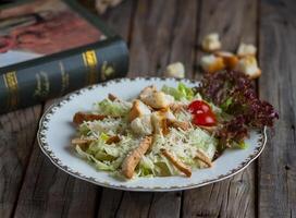 fresco saudável frango César salada servido dentro uma prato isolado em de madeira fundo lado Visão foto