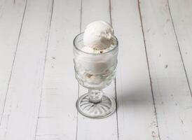 coco gelo creme colher servido dentro copo isolado em mesa topo Visão do sobremesa foto