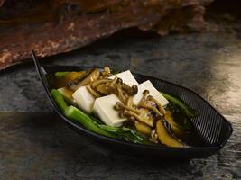 refogado tofu com sortido cogumelo servido dentro prato isolado em mesa topo Visão do Comida foto