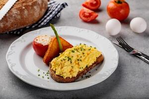 ovos seu caminho com pão e tomate servido dentro prato isolado em mesa topo Visão do árabe café da manhã foto