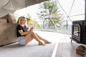 tiro do uma lindo mulher usando uma Smartphone enquanto relaxante às casa foto