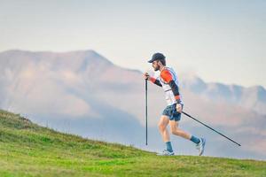 atleta praticando caminhada nórdica nas colinas foto