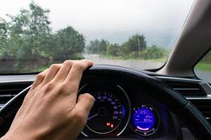 viagem conceito. do homem mão dentro uma carro em uma chuvoso dia com natureza fundo. depois de alguns Editar% s. foto