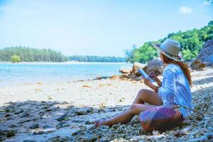 mulher asiática viajar natureza. viajar relaxar. estudo ler um livro. educação da natureza escreva uma nota. na praia. no verão. Tailândia foto