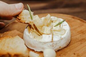 branco baguete com Oliva óleo e cozido queijo Camembert queijo em a mesa. foto