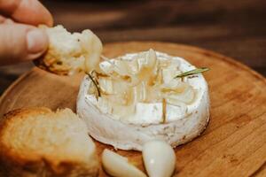 branco baguete com Oliva óleo e cozido queijo Camembert queijo em a mesa. foto