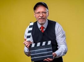 Senior homem detém filme aba fechar acima. filme dirigindo. filme Produção. humano emoções. homem com filme aba enquanto filmando foto