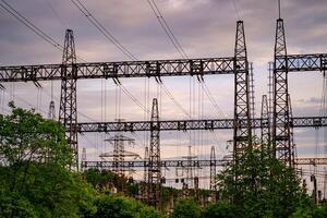 eletricidade postes rolamento a poder fornecem através uma rural panorama durante pôr do sol. seletivo foco. foto