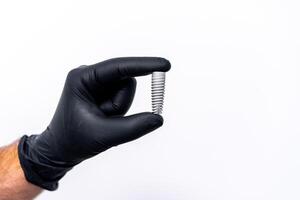 tecnologia do dente implantes isolado em branco dentro dentista s mão. Preto látex luvas. foto