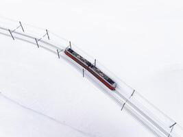 brilhante vermelho elétrico trem ascendente Nevado declive dentro zermatt, Suíça foto