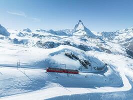 aéreo Visão do zermatt esqui recorrer com vermelho trem e Matterhorn, Suíça foto