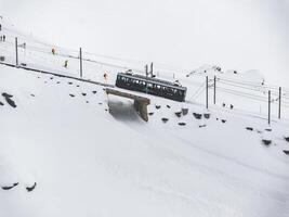inverno trem com esquiadores às a zermatt esqui recorrer dentro Suíça. foto