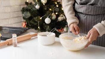 mulher sorridente na cozinha fazendo biscoitos de natal foto