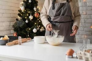 mulher sorridente na cozinha fazendo biscoitos de natal foto