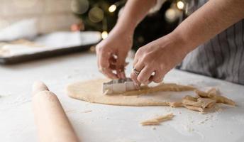 mulher sorridente na cozinha fazendo biscoitos de natal foto