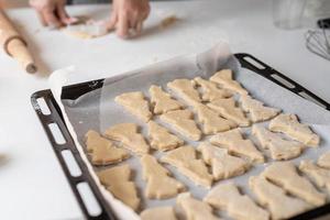 mulher sorridente na cozinha fazendo biscoitos de natal foto