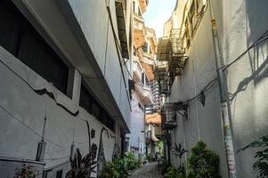 uma limitar beco com de vários andares casas em a Beira dentro uma densamente populosa urbano Centro, Indonésia, 2 marcha 2024. foto