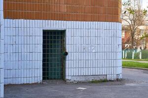 Sombrio metal porta orifício com bares em uma branco lado a lado parede foto