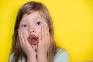 assustado pequeno menina comendo chocolate sujo cara.menina parece para a Câmera. fechar acima do criança com sujo face dentro chocolate .cópia de espaço foto