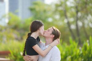 uma casal é desfrutando uma verão período de férias dentro a parque, alegremente mostrando seus amor para cada outro. foto